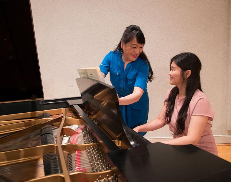 教授帮助学生练习钢琴演奏